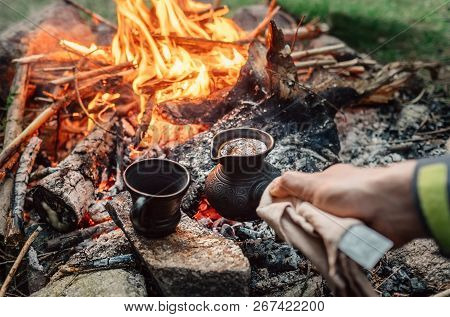 Luxury Camping Concept. Fresh Coffee Prepared In Turkish Cezva On Campfire Coals.