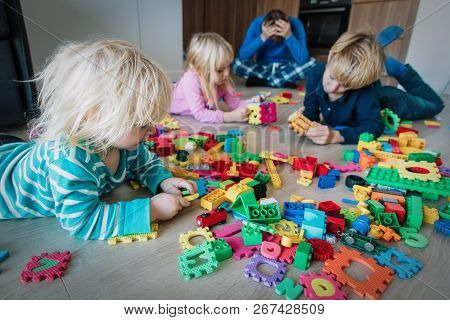 Kis Play At Home With Toys Scattered All Over And Tired Exhausted Father