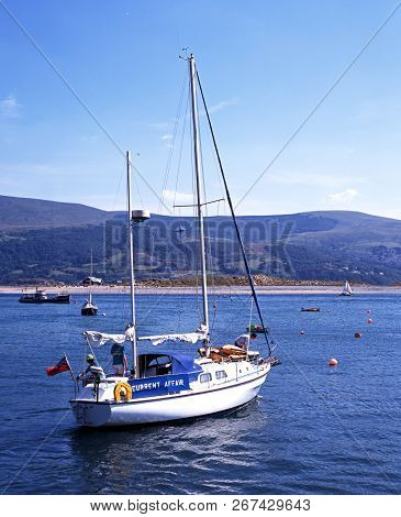 Barmouth, United Kingdom - August 6, 1995 - Yacht In The Harbour With Views Towards Fairbourne Beach