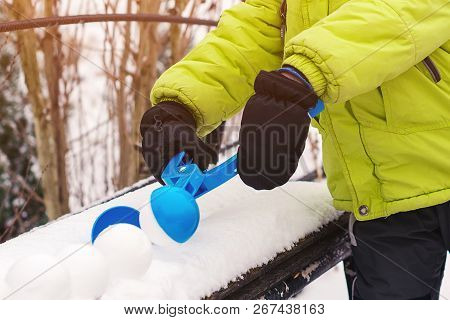 Little Boy Makes Snowballs With Snowball Maker. Happy Child Playing With Snow. Cold Winter Weather. 