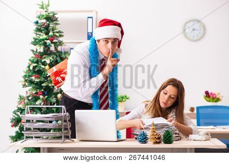 Colleagues exchaing christmas presents in office