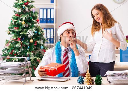 Colleagues exchaing christmas presents in office