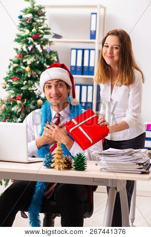 Colleagues exchaing christmas presents in office