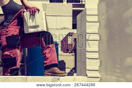Unrecognizable Woman Working On Construction Site, Building House, Installing Gray Airbricks. Indust