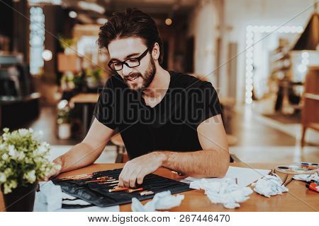 Young Male Talanted Artist Focused On Paining. Closeup Portrait Of Handsome Painter Sitting At Woode
