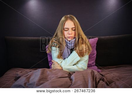 Young Female Person Got Cold. She Wears White Sweater And Blue Scarf. Young Woman Is Sick. She Keeps