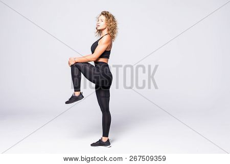 Side View Of A Sporty Young Woman Jumping Isolated On White Background