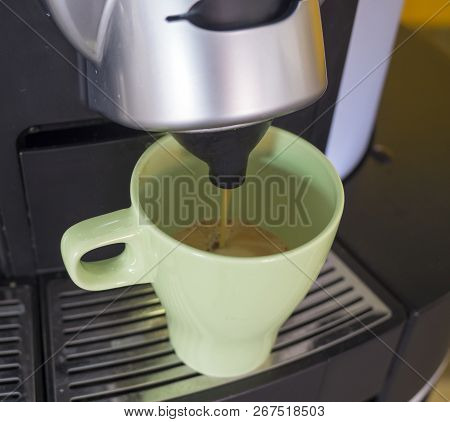 Close-up Of Espresso Lungo Pouring From Coffee Machine In A Green Ceramic Cup