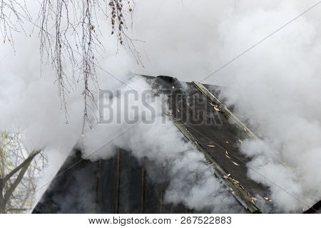 White Smoke Comes From The Burning Roof Of The House