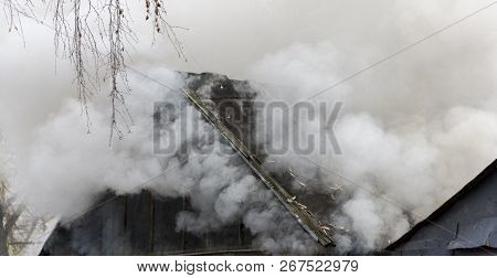 White Smoke Comes From The Burning Roof Of The House