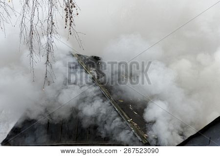 White Smoke Comes From The Burning Roof Of The House