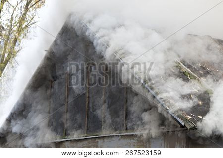 White Smoke Comes From The Burning Roof Of The House
