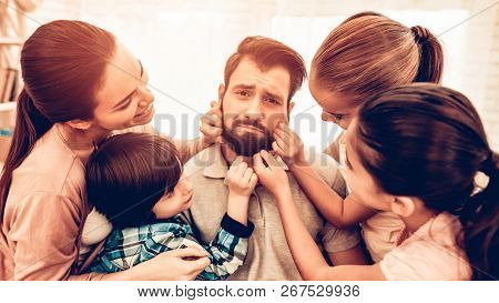 Tired Dad With Happy Cute Family Annoying. Dad After Work Sitting On Sofa With Playing Loud Three Ki