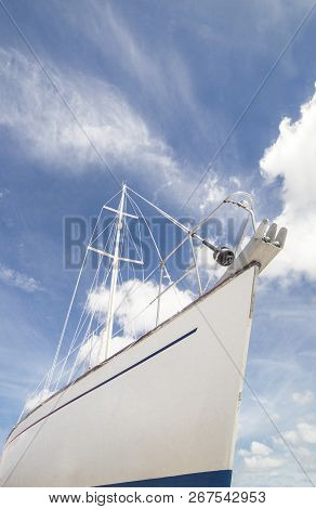 Sailboat Prow Over Blue Cloudy Sky. Low Angle Side View