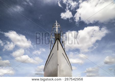 Sailboat Prow Over Blue Cloudy Sky. Low Angle Front View