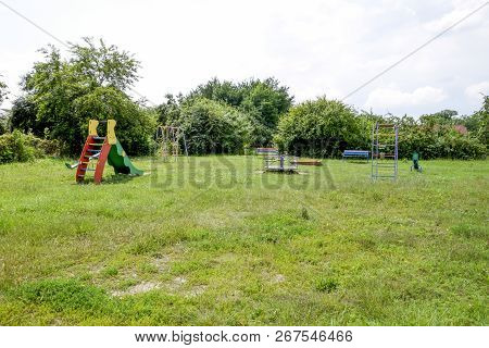 A Childrens Playground. Swing, Carousel And Slide