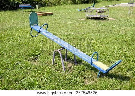 Childrens Playground. Swing, Carousel And Slide. Childrens Rocking Chair On The Playground.
