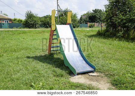 A Childrens Playground. Swing, Carousel And Slide