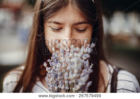 Beautiful Stylish Young Woman Holding Amazing Lavender Flowers And Smelling Them In Sunny Outdoors. 