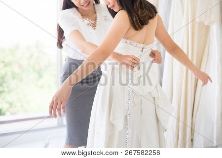 Happy Woman Designer Making Adjustment In Fashion Studio,asian Bride Smling And Trying On Wedding Dr