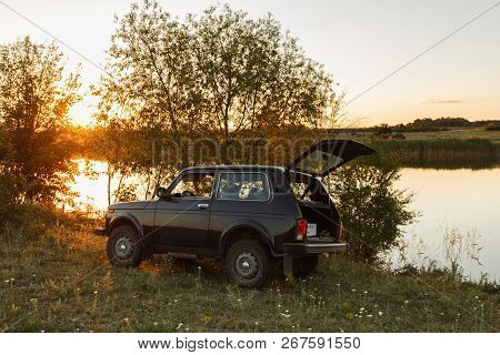 Dnipropetrovsk Region, Ukraine - June 19, 2017: Vaz Niva Blue-green Color Near The River On Sunset, 