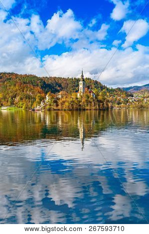 Panorama Of Lake Bled With Church And Pletna Boats, Slovenia And Autumn Colorful Trees Background