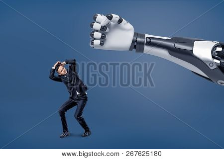 A Giant Robotic Hand Is Ready To Hit A Tiny Scared Businessman With A Fist.