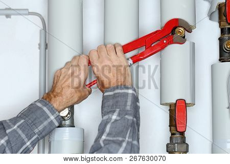 Worker With Gripper In Hand Is Fixing A Pipe
