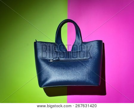 Fashionable Women's Leather Handbag On A Green Pink Neon Background. Pop Light.
