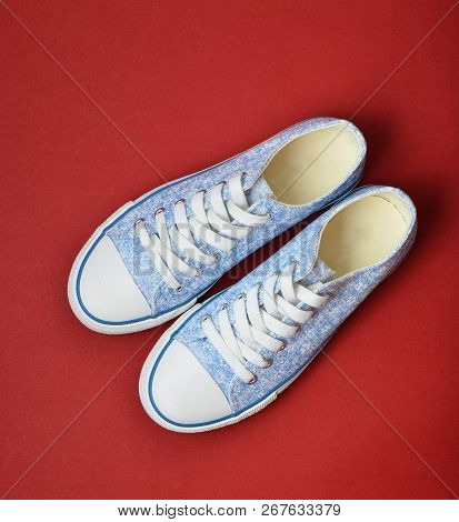 Classic Retro Sneakers On A Red Background. Top View. Women's Shoes.