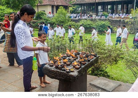 Kandy, Sri Lanka - July 19, 2016: White Clothed Buddhist Devotees Light Candles At The Temple Of Sac
