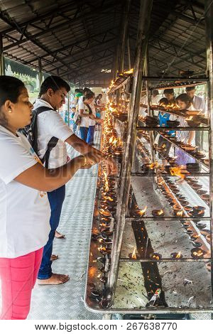 Kandy, Sri Lanka - July 19, 2016: White Clothed Buddhist Devotees Light Candles At The Temple Of Sac