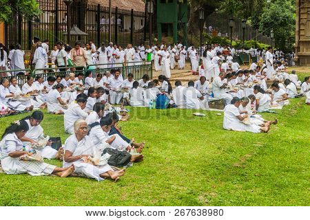 Kandy, Sri Lanka - July 19, 2016: White Clothed Buddhist Devotees Eat At The Grounds Of The Temple O