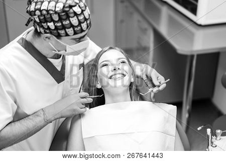 Dentist Examine Female Patient With Braces In Denal Office.