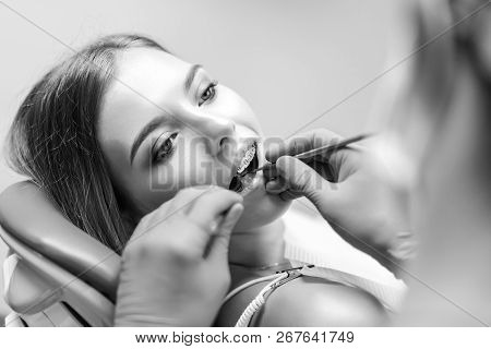Dentist Examine Female Patient With Braces In Denal Office.