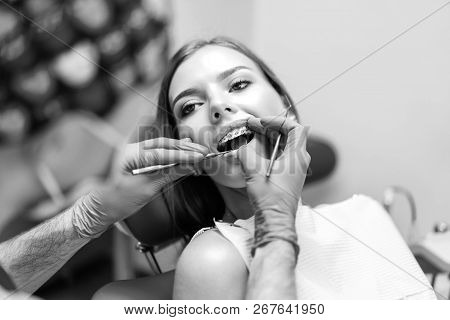 Dentist Examine Female Patient With Braces In Denal Office.