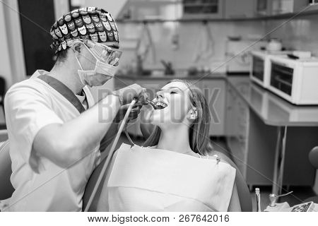 Dentist Examine Female Patient With Braces In Denal Office.