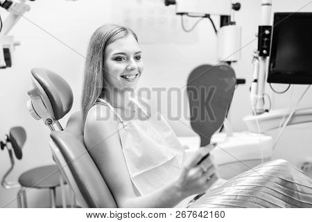 Happy Pretty Female Patient In Dental Office.
