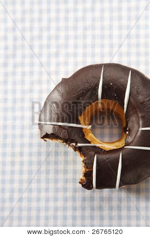 En chokolade omfattet doughnut med en bid, taget fra den.