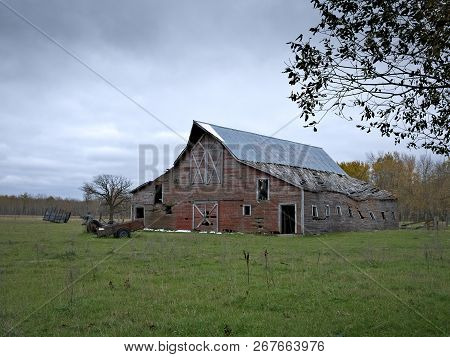 Dreary Abandoned Dilapidated Farm Barn With Cloudy Skies In Northern Minnesota