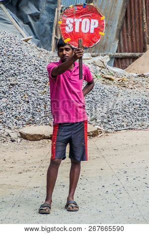 Ella, Sri Lanka - July 14, 2016: Local Worker Holding A Stop Sign Near Ella Village.