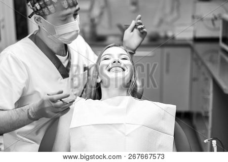Dentist Examine Female Patient With Braces In Denal Office.