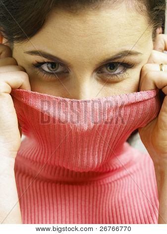 女性のタートルネック、カメラ目線で顔を覆う