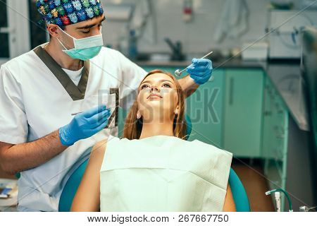 Dentist Examine Female Patient With Braces In Denal Office.