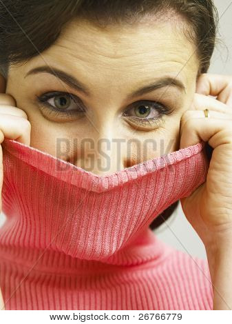 女性のタートルネック、カメラ目線で顔を覆う