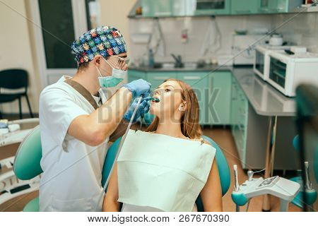 Dentist Examine Female Patient With Braces In Denal Office.