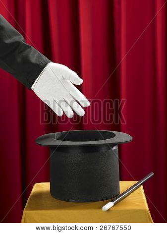 Mains du magicien avec chapeau haut de forme et de la baguette magique sur scène.
