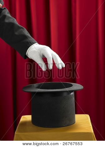 Mains du magicien avec chapeau haut de forme sur scène.