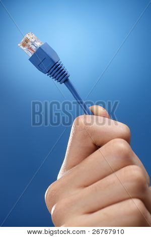 มือมนุษย์ที่ถือครองการใช้สายเคเบิลเชื่อมต่ออินเทอร์เน็ต