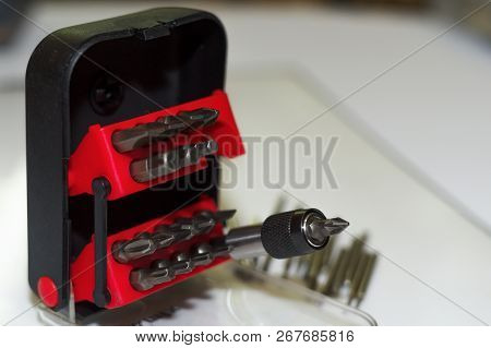 Bits Holder In Box And Many Tool Bits On White Background. Close-up View. Red Element In Plastic Box